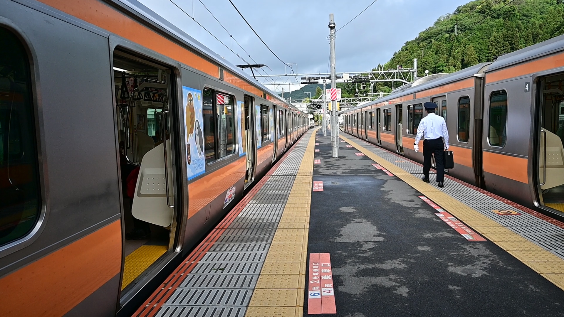 Getting to Mt. Kawanori from central Tokyo is quite straightforward. Take my lovely 'Holiday Rapid Okutama No.1' from Track No.11 of Shinjuku Station at 6:45am — it arrives in Ōme at 7:46am. From there, simply hop off and transfer to the train in front, which continues to Okutama Station, arriving at 8:24am. This connecting service is specifically designed for Tokyo hikers and is often packed with fellows and their backpacks — you’ll be part of the crowd.<br />
<br />
Upon arrival at Okutama station, you'll have just 11 minutes before the bus to Mt. Kawanori’s trailhead departs. Many hikers, especially ladies, make a quick stop at the restroom before setting off, but be warned — the facility on the left side from the station exit is always crowded. I have to say the sharp and punctual 11-minute connection time — it’s a very Japanese approach to efficiency — but wouldn’t a 30-minute gap make everyone happier?<br />
<br />
Finding the bus to Kawanori’s trailhead is simple — it departs from the right side of the station exit, easily identifiable by the long queue of hikers waiting to board. 01