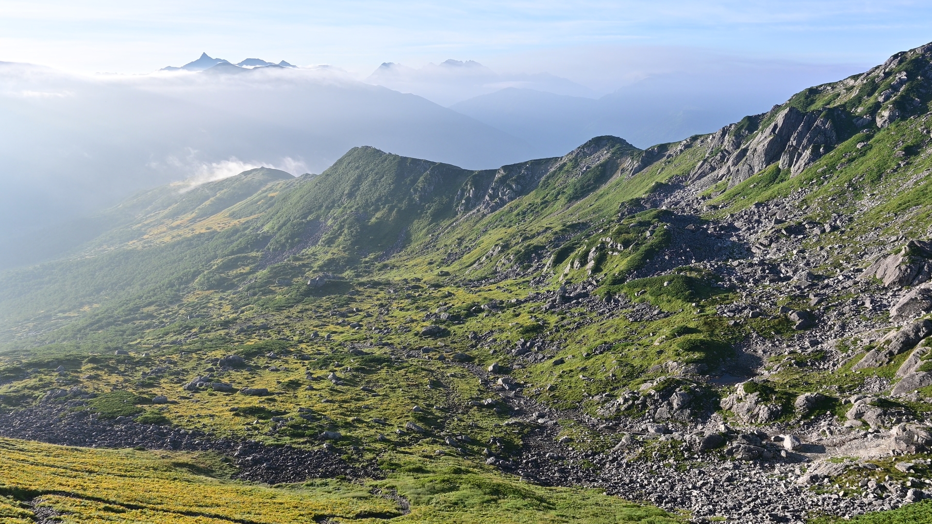 The highlight of this hike may be the cirque of Mt. Kurobe-Goro, located on the southern rim of Kurobe's headwaters. Directly from the pyramidal peak of Mt. Kurobe-Goro lies the largest cirque, which drops steeply down to the riverbed of the Kurobe River. This combination of glacial and volcanic terrain is a distinctive feature of this range, and more broadly, of the Japanese Alps. 01