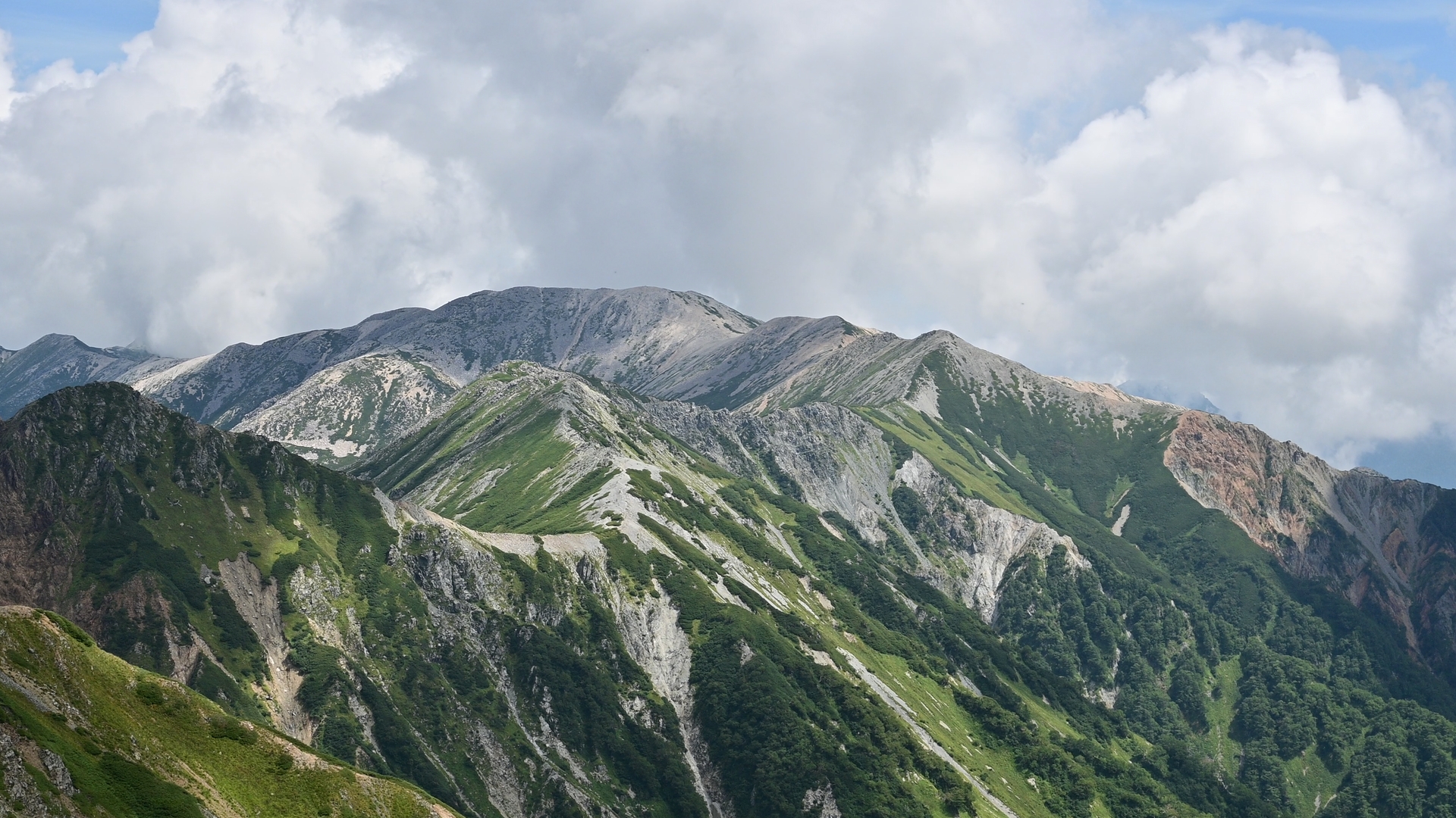 Mt. Noguchi-Goro, a broad peak with an elevation of 2,924 meters, lies far to the east. Mt. Washiba, whose name literally means “eagle wing,” spreads its ridges like outstretched wings at Kurobe's headwaters. And there is a small volcanic crater lake below its summit.<br />
However, the scenery depends greatly on the weather. If you have enough spare days during your stay in Japan, I would highly recommend staying in Kumo-no-Daira for a couple of days and climbing the surrounding peaks. Then the probability to enjoy good weather will be increased. 01